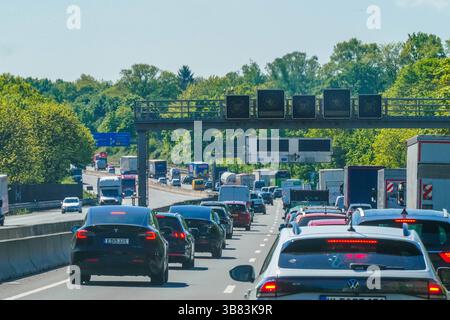 Verkehr staut sich auf der Autobahn dichtes Aufkommen bei sommerlichem Wetter - Nordrhein-Westfalen, Deutschland, Europa Starker Verkehr und Rückstau auf der Autobahn. Zahlreiche Pkw, LKW und Transporter bewegen sich im dichten Verkehr unter digitalen Verkehrsschildern, Die Tempolimits anzeigen. DAS Bild steht symbolisch für die Überlastung des Straßennetzes und die täglichen Herausforderungen im deutschen Pendler- und Transitverkehr. *** Ingorghi stradali traffico intenso in estate Renania settentrionale-Vestfalia, Germania, Europa traffico intenso e code-back sull'autostrada numerose automobili, Foto Stock