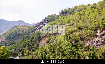 Tradizionale architettura Cinese accoccolata nel lussureggiante paesaggio montuoso di Wangxian Valley Town, Shangrao, provincia di Jiangxi, Cina Foto Stock