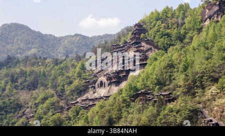 Tradizionale architettura Cinese accoccolata nel lussureggiante paesaggio montuoso di Wangxian Valley Town, Shangrao, provincia di Jiangxi, Cina Foto Stock
