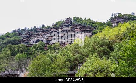 Tradizionale architettura Cinese accoccolata nel lussureggiante paesaggio montuoso di Wangxian Valley Town, Shangrao, provincia di Jiangxi, Cina Foto Stock