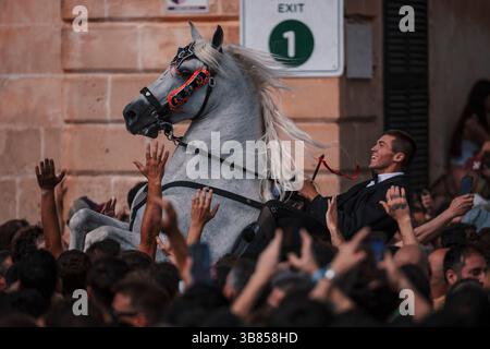 23 giugno 2024, Ciutadella De Menorca, Isole Baleari, Spagna: Un "caixer" (cavaliere) si alza sul suo cavallo circondato da una folla di tifo durante la "Caragol des Born" (parata di cavalli) alla vigilia della tradizionale festa di Sant Joan (San Giovanni). (Immagine di credito: © Matthias Oesterle/ZUMA Press Wire) Foto Stock