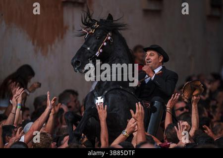 23 giugno 2024, Ciutadella De Menorca, Isole Baleari, Spagna: Un "caixer" (cavaliere) si alza sul suo cavallo circondato da una folla di tifo durante la "Caragol des Born" (parata di cavalli) alla vigilia della tradizionale festa di Sant Joan (San Giovanni). (Immagine di credito: © Matthias Oesterle/ZUMA Press Wire) Foto Stock