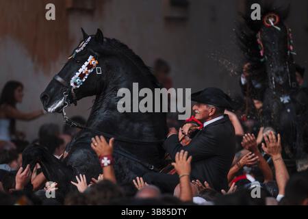 23 giugno 2024, Ciutadella De Menorca, Isole Baleari, Spagna: Un "caixer" (cavaliere) si alza sul suo cavallo circondato da una folla di tifo durante la "Caragol des Born" (parata di cavalli) alla vigilia della tradizionale festa di Sant Joan (San Giovanni). (Immagine di credito: © Matthias Oesterle/ZUMA Press Wire) Foto Stock