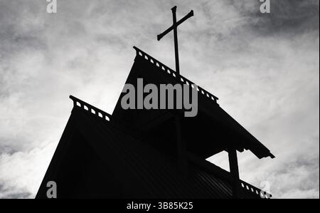 Primo piano della sagoma di una guglia della chiesa con una croce contro un cielo nuvoloso, sfondo Kristin Lavranstochter film, Jorundgard Middelaldersenter, O. Foto Stock