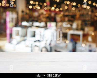 Tavola bianca di legno vuota davanti a sfondo sfocato. Il legno bianco prospettico sulla sfocatura nel negozio di scarpe. Mockup per visualizzazione o montaggio Foto Stock