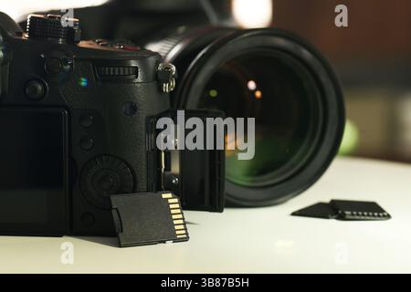 Schede di memoria SD e fotocamere su tavolo bianco, primo piano Foto Stock