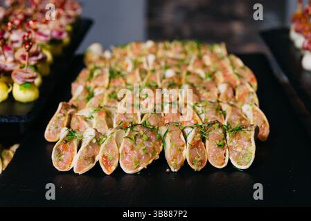 Primo piano di mini tacos gourmet ripieni di tartare di tonno fresco ed erbe aromatiche, perfetti per catering di alto livello e vassoi antipasti. Foto Stock