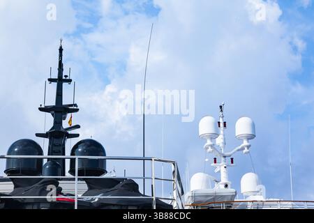 Albero di un grande yacht di lusso con equipaggiamento di navigazione, vista dal basso. Radar, luci di segnalazione, parabole satellitari e apparecchiature. Foto Stock