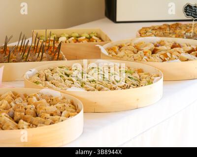 Elegante buffet di antipasti nuziali con una varietà di stuzzichini, perfetto per cocktail hour o catering per ricevimenti. Foto Stock