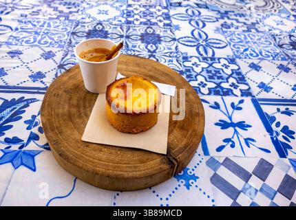 Espresso e pasticceria sul tavolo del ristorante portoghese rustico Foto Stock