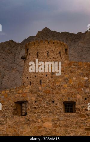 Oman: Il forte di al Qala contro la montagna a Bukha, un villaggio di pescatori nella penisola di Musandam, il punto nord-orientale della penisola arabica Foto Stock