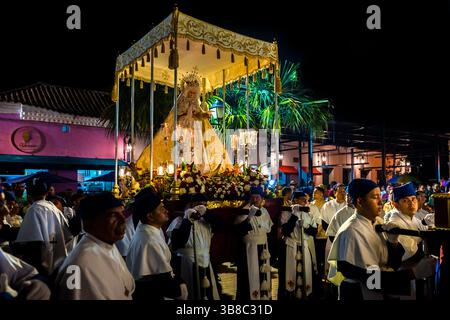 Nazarenos, devoti membri di una confraternita religiosa, portano un galleggiante (paso) durante la processione della settimana Santa a Mompox, Colombia. Foto Stock