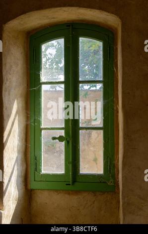 Una bella finestra verde mostra in modo prominente una ragnatela sulla sua superficie Foto Stock