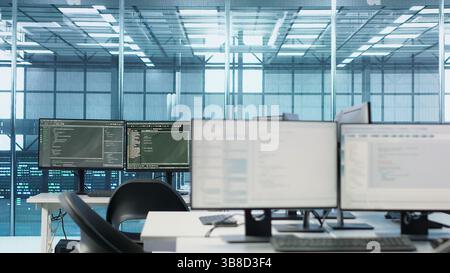 Codice in esecuzione sugli schermi dei computer in uno spazio di lavoro vuoto del data center, utilizzato per la risoluzione dei problemi relativi ai montaggi su rack. Primo piano dello script che lavora sui monitor dei PC desktop che aggiornano i sistemi mainframe nella sala server Foto Stock