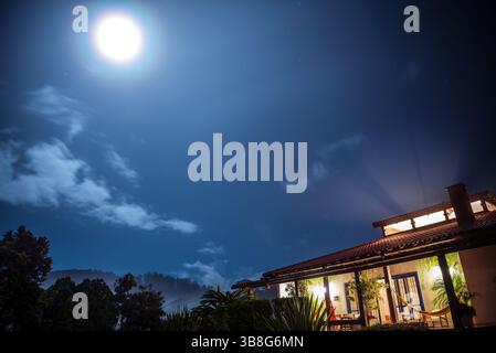Luna piena sopra una casa di campagna a Itaipava, Brasile Foto Stock