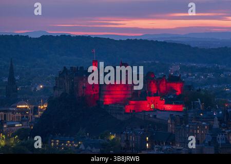 Foto del 80° anniversario del VE Day, datata 06/05/25, del Castello di Edimburgo, illuminata di rosso come monumenti storici in tutto il Regno Unito. La Scozia è destinata a rendere omaggio ai suoi eroi del tempo di guerra con eventi che si svolgono in tutto il paese per celebrare il 80 ° anniversario del VE Day. Data di pubblicazione: Giovedì 8 maggio 2025. Foto Stock