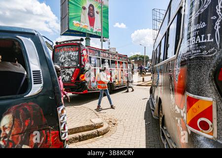 7 marzo 2024, Nairobi, Nairobi, Kenya: Un uomo gesta mentre cammina tra matato in una stazione nella zona di Ngong Hill a Nairobi. Matatu, o mathree a sheng, è una tipica forma di trasporto, derivata dagli anni '60 e sempre più diffusa nella fiera quotidiana di oltre il 70% keniani a Nairobi. Sono decorate in modo elaborato e sono profondamente parte della cultura keniota, a differenza di altre parti dell'Africa orientale. (Immagine di credito: © Bianca Otero/ZUMA Press Wire) Foto Stock