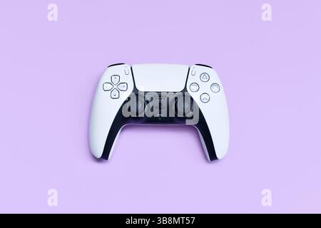 Germania - maggio 2025: Controller di gioco bianco per PlayStation 5 su sfondo viola pastello Foto Stock
