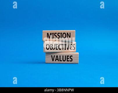 Simbolo dei valori degli obiettivi della missione. Parole concettuali obiettivi della missione valori su blocchi di legno. Bellissimo sfondo blu. Obiettivi aziendali e di missione Foto Stock