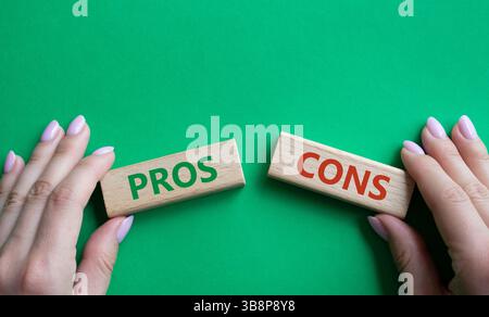 Simbolo pro e contro. Parola concettuale Pro vs contro su blocchi di legno. Mano d'affari. Bellissimo sfondo verde. Business e Pro vs Cons Concept. Copia Foto Stock
