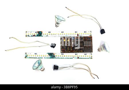 Schede elettriche bruciate e microcircuiti con lampadine e fili su sfondo bianco. Foto Stock