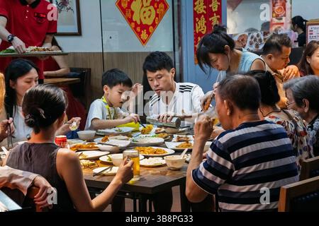 Una famiglia cinese che gusta una cena in un ristorante, Chinatown, Singapore Foto Stock