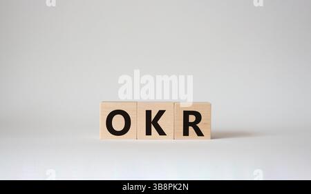 Obiettivi OKR e simbolo dei risultati chiave. Cubi in legno con parole obiettivi OKR e risultati chiave. Splendido sfondo bianco. Obiettivi aziendali e OKR Foto Stock