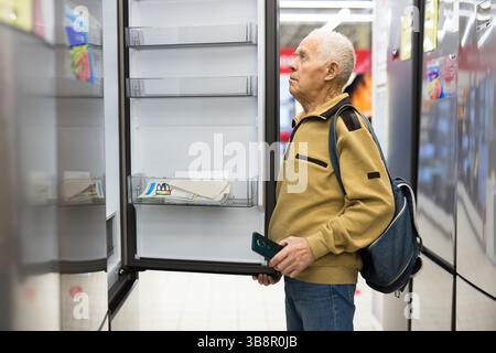 Pensionato Senor MAN che acquista un frigorifero nello showroom del negozio di elettrodomestici Foto Stock