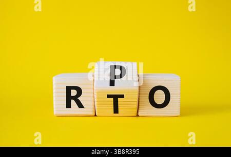 Simbolo RPO vs RTO. Cubi di legno con le parole RTO e RPO. Bellissimo sfondo giallo. concetto di business. Copia spazio Foto Stock