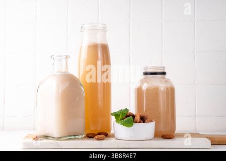 Sciroppo d'Orgeat alle mandorle fatto in casa in diverse bottiglie, mandorle, acqua, zucchero e sciroppo d'acqua al fiore d'arancia per preparare cocktail dolci Foto Stock