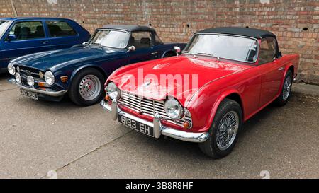 Due Trionmph Roadster, un Red, 1964, TR4 e un 1973, Blue TR5, in mostra al Brooklands Museum durante l'Easter Classic Gathering Foto Stock