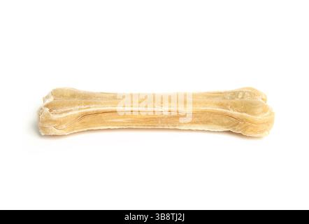Osso di masticazione isolato di rawhide per cani. Vista laterale del mastice di salute dentale a forma di osso. Utilizzato per cani e l'arricchimento del cucciolo, la salute dentale e happin Foto Stock