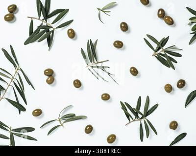 Bellissimo disegno con olive verdi e foglie di olivo e rami su sfondo bianco. Frutta e rami di olivo come modello, vista dall'alto o fl Foto Stock