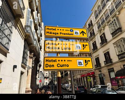 Malaga, Spagna - 2 maggio 2025: Segnali direzionali a Malaga che portano agli hotel, catturati in un ambiente urbano affollato Foto Stock