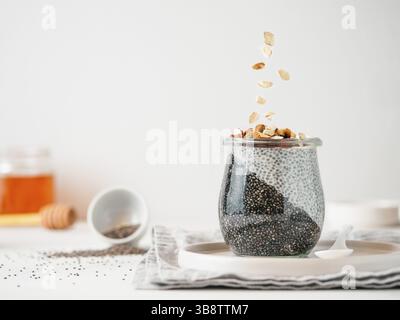 Colazione salutare concetto e idea - due colori chia pudding con materie organiche di mandorla. Il vasetto di vetro con il nero antracite e bianco latte vegano budino di Chia Foto Stock