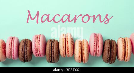 Concetto di macaron. Lettere macaron su bacground turchese e fila di macaron francesi Foto Stock