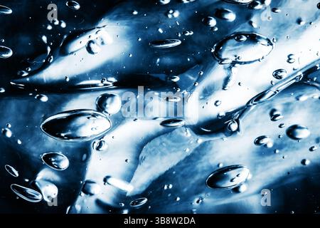 Consistenza del gel con bolle d'aria. Primo piano di gel cosmetico blu trasparente. Fondo liquido trasparente. Schema del fluido astratto con goccioline. Foto Stock