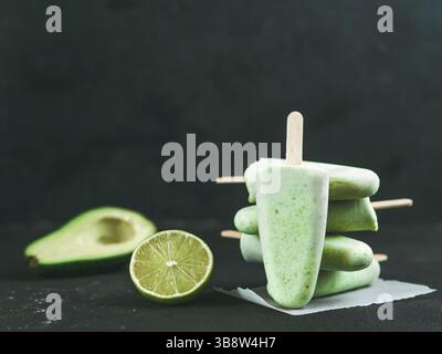 In casa materie vegane avocado lime ghiaccioli. Senza zucchero, non-dairy verde ice cream on nero testurizzato sfondo. Copia dello spazio. Idee e ricette per la salute Foto Stock