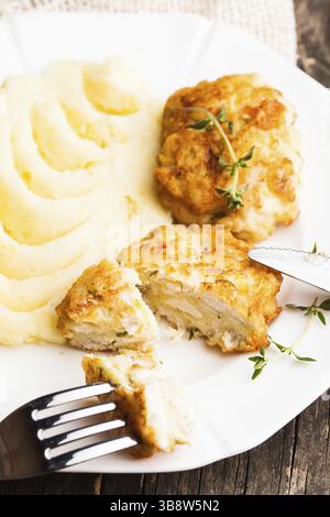Cotolette di pollo e purè di patate in una piastra da vicino Foto Stock