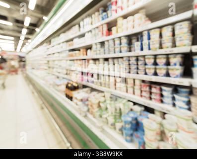 Sfocatura sfocati di scaffali del supermercato con lavorazione del latte e la maionese prodotti in frigorifero. La sfocatura dello sfondo con bokeh di fondo. Immagine sfocati Foto Stock