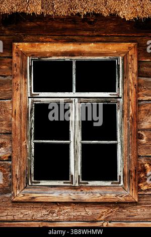 Telaio della finestra in legno rustico. Architettura tradizionale della cabina in legno. Sfondo vuoto del vetro nero. Dettagli vintage in campagna. Foto Stock