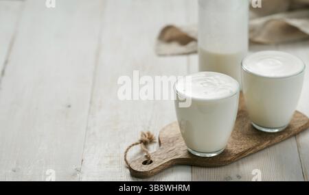 Kefir, latticello o yogurt con probiotics.yogurt in vetro su sfondo bianco di legno.probiotic freddo fermentato latticini drink.Gut salute, fermentato prod Foto Stock