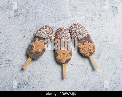 Popolsicolo Chia con torta di carote crude e cioccolato su sfondo grigio. Ricetta sana e idea gelato di papsicle vegane fatte in casa. Idea di dessert di Pasqua. C Foto Stock