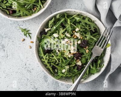 Barbabietola, aragola e insalata di formaggio morbido su sfondo grigio. Vista dall'alto o in piano. Spazio di copia per il testo. Idea e ricetta per una sana estate vegetariana Foto Stock
