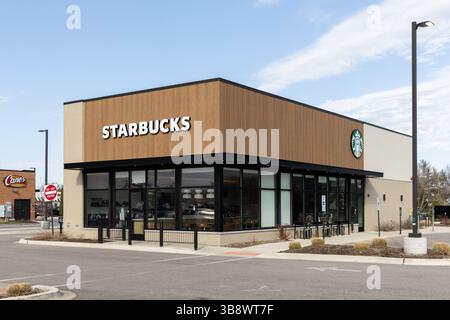 Un nuovo punto vendita Starbucks con un cielo blu. Starbucks è una delle più grandi catene mondiali di caffè con sede a Seattle, Washington. Foto Stock