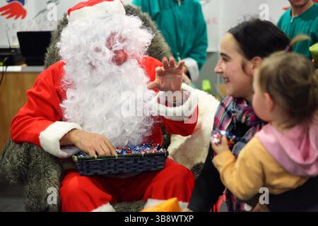 Francia Digione : le père Noël rouge distribue les cadeaux lors de l'évènement des Pères Noël verts organisé par le Secours Populaire francese Foto Stock