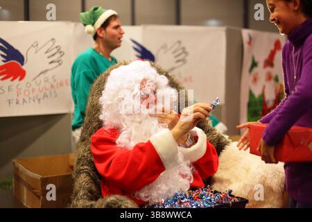 Francia Digione : le père Noël rouge distribue les cadeaux lors de l'évènement des Pères Noël verts organisé par le Secours Populaire francese Foto Stock