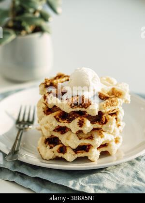 Ricotta formaggio chaffles per la dieta del keto. Pila di ricotta e waffle belgi al limone decorata con scoop gelato. Spazio di copia per testo o disegno. Natur Foto Stock