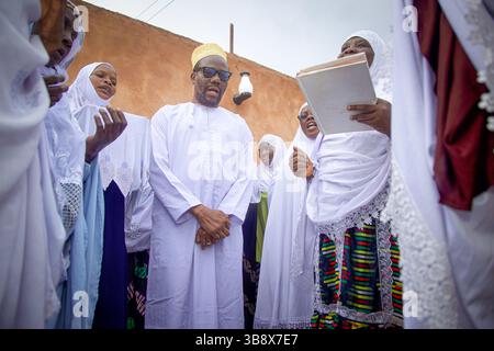 Donne musulmane che hanno completato l'Hajj pregando per l'ex leader del partito Wazalendo Zitto Kabwe nella sua casa nella città di Kigoma, Tanzania Foto Stock