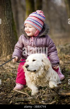 Ragazza con il recupero d'oro stanno giocando nel parco Foto Stock